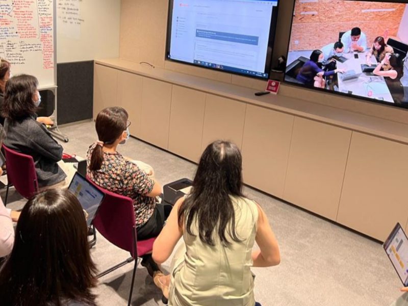 Colleagues in an observation room watching a live usability test on screen
