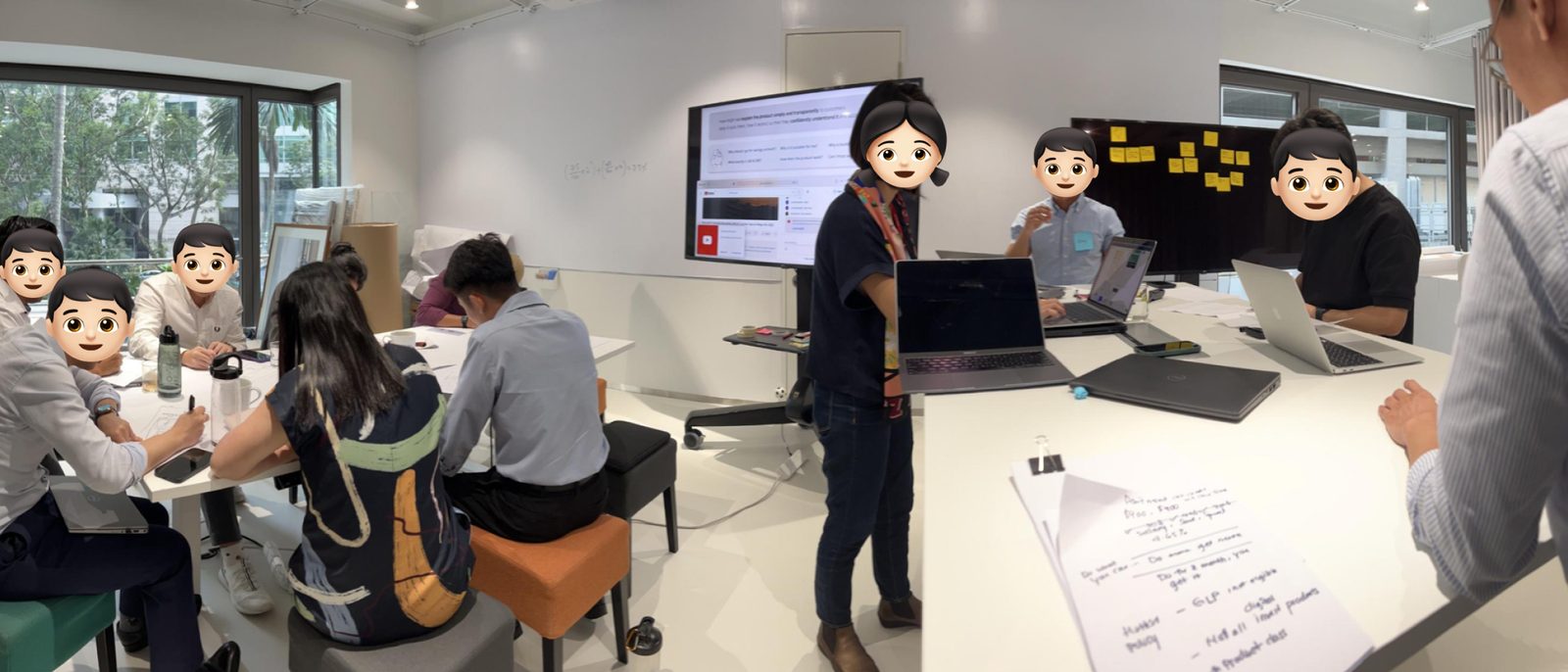 A workshop in progress: teams sketching ideas at tables and working on laptops